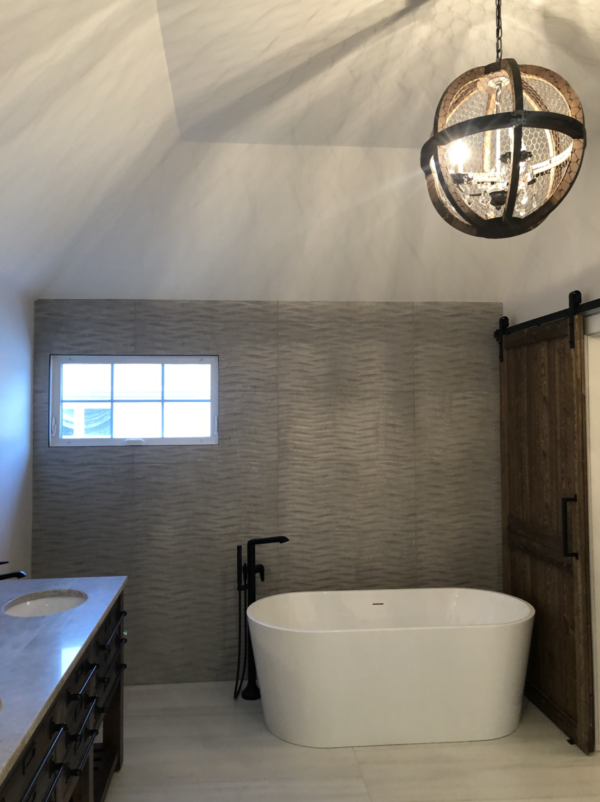 Modern Farmhouse-inspired Bathroom with Barn Door, Gray Flooring and Accent Wall