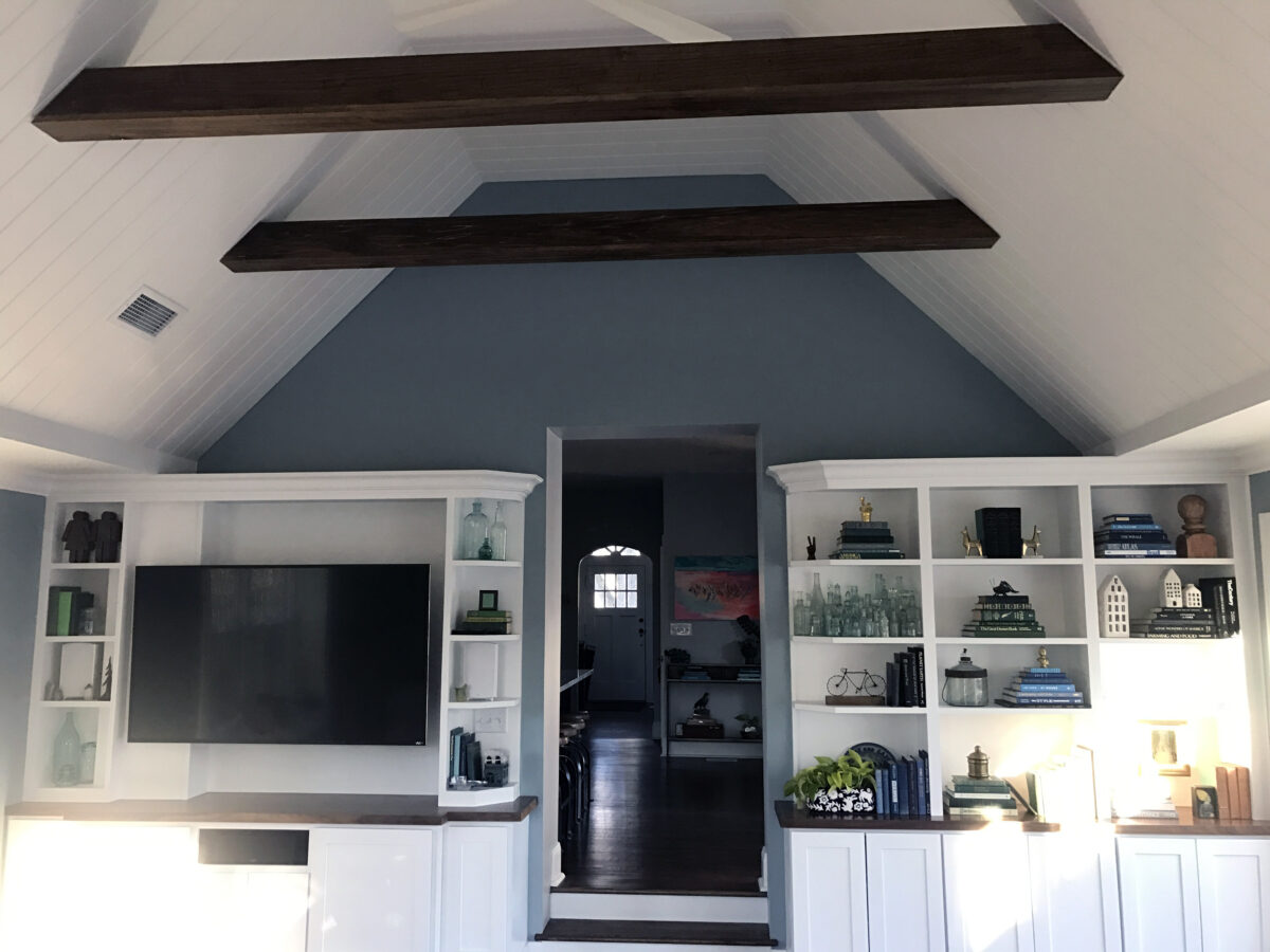Coastal Inspired White Ceiling with Wooden Beams, White Built-in Entertainment Center and Bookshelf