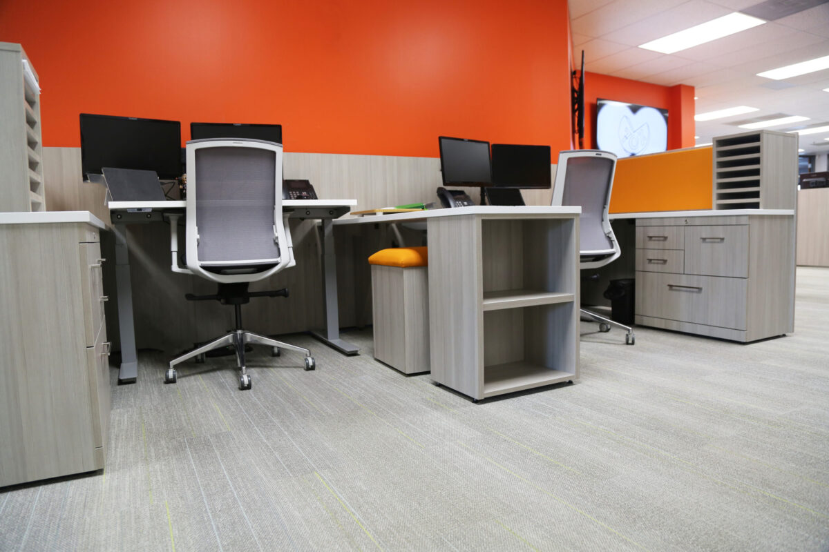 Commercial Office Workstations with Gray Desks, Orange Walls, and Gray Flooring