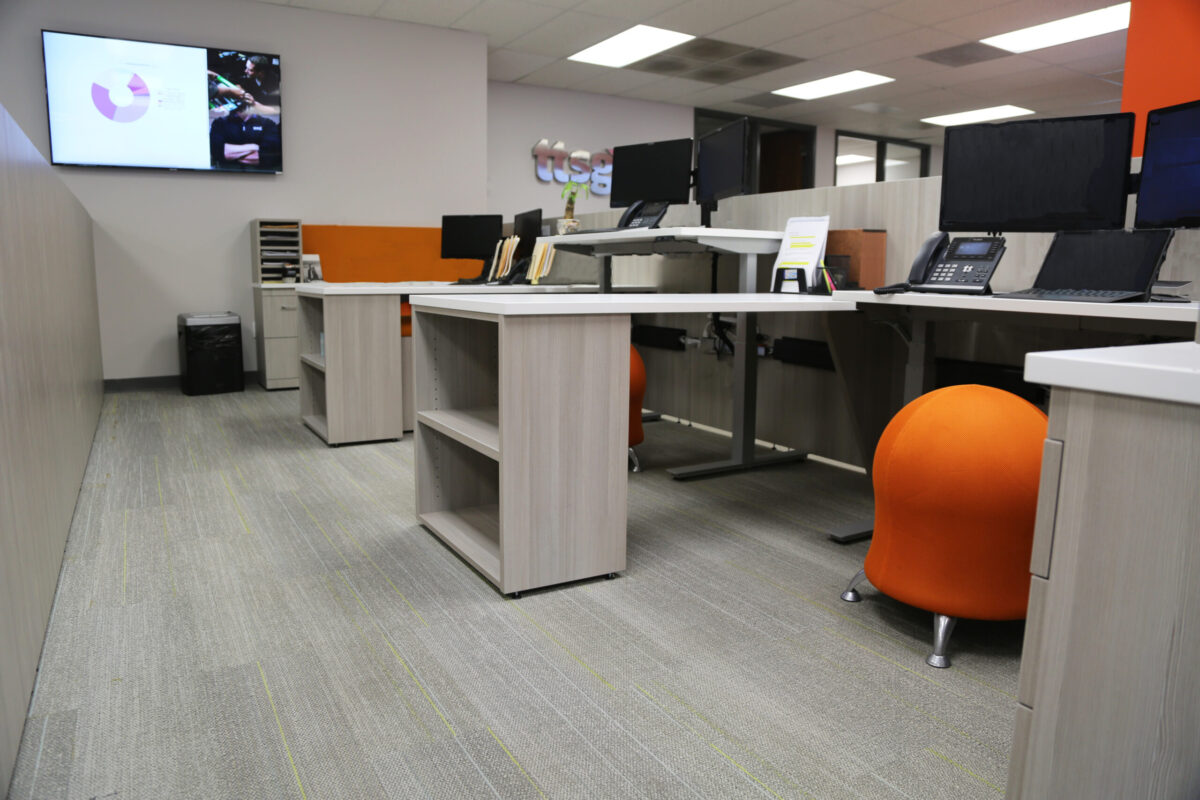 Commercial Office Workstations with Gray Desks, Orange Walls, and Gray Flooring